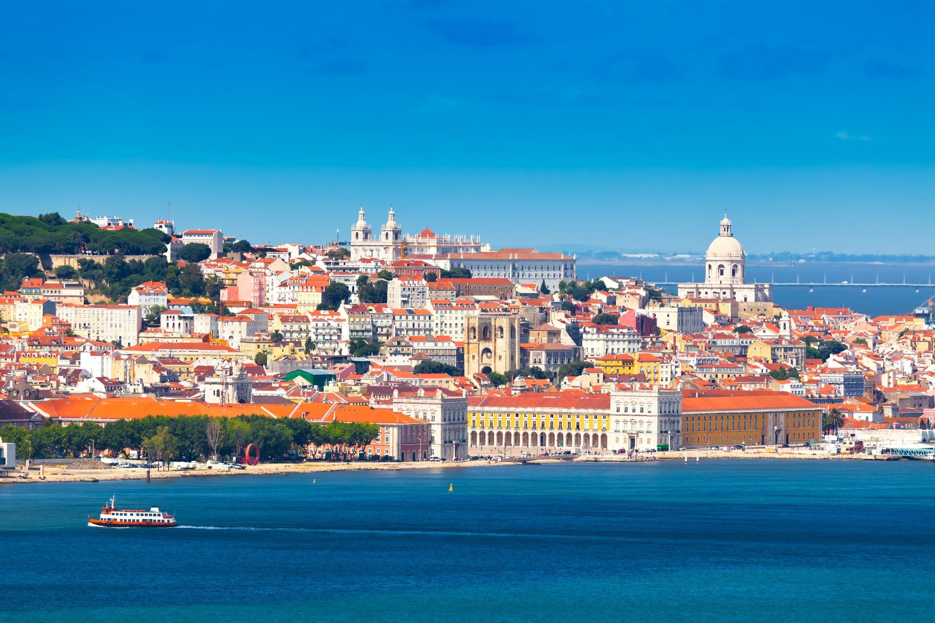Panoramablick auf die Altstadt von Lissabon mit Praça do Comércio und dem Tejo-Fluss im Vordergrund.